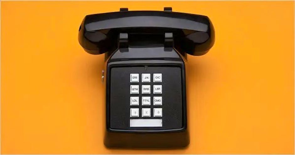 An old-style push-button landline telephone, against a yellow background.